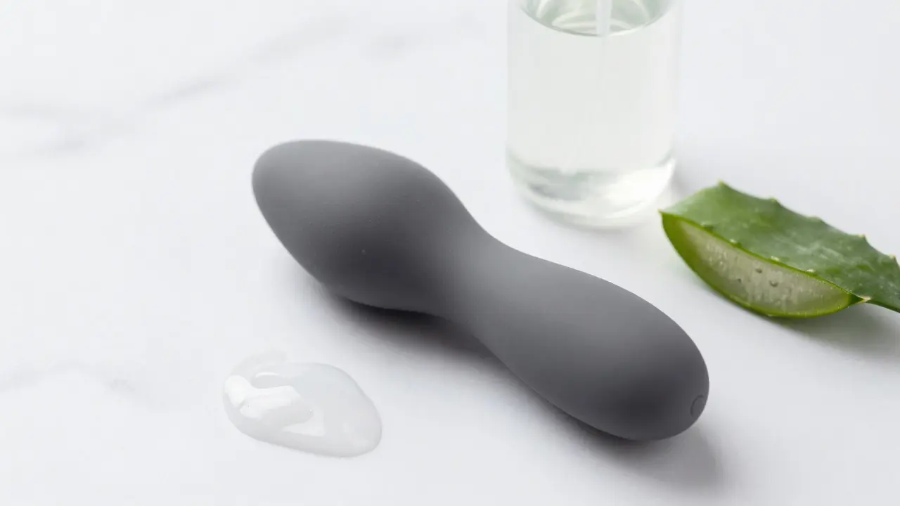 Silikonový masér a lubrikační gel na mramorovém povrchu